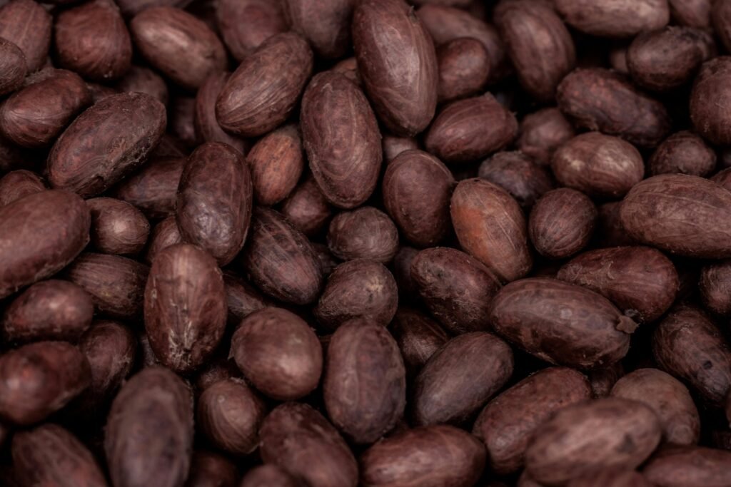 A detailed close-up of raw cocoa beans from Nigeria, showcasing their natural texture and rich color.